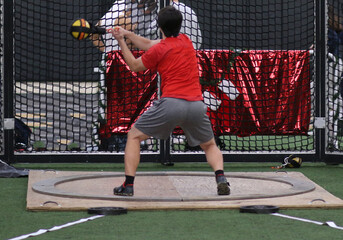 Athlete in a hot put circle throwing an indoor weight