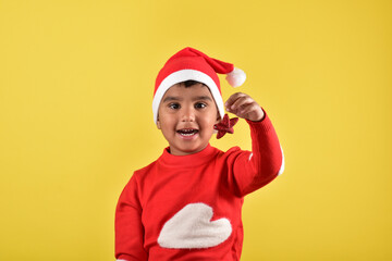 Child boy wearing santa cap and holding decorative things for christmas 