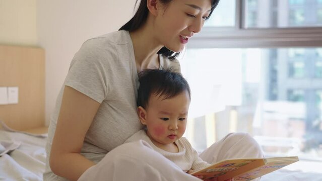 Young Chinese mother spending time with her baby