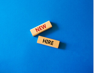 New hire symbol. Wooden blocks with words New hire. Beautiful blue background. Business and New hire concept. Copy space.