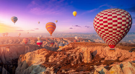Amazing Panoramic view sunrise rocky landscape in Cappadocia with colorful hot air balloon deep...