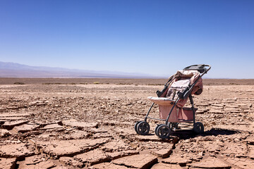 Desertification: symbolic image for climate change - Abandoned stroller on dry soil in the Atacama...