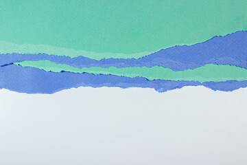 Ripped up pieces of coloured paper and copy space on white background