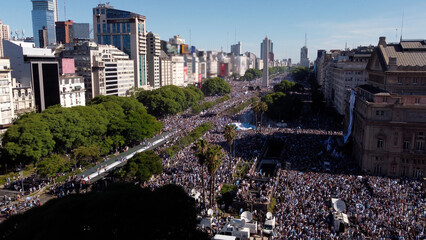 Crowd in Buenos Aires streets full of argentinian supporters. Aerial footage. Argentina wins Qatar 2022 Soccer World Cup. 9 de Julio Avenue and Obelisk at background.
