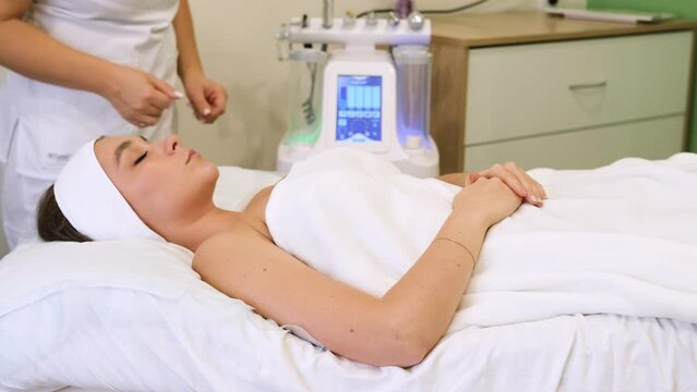 The cosmetologist turns on the beauty combiner and starts preparing for the procedure. Slow motion horizontal video