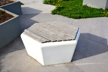 white plastic and wooden bench isolated on concrete background, close-up