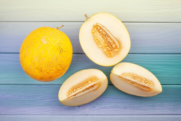 sliced yellow melon on wood background top view - obrazy, fototapety, plakaty