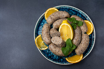 Traditional meat delicacies, sausages on a dark table
