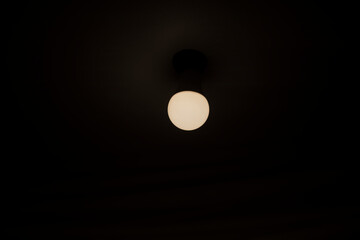 Lamp on ceiling. Dim light in room. Lighting device.
