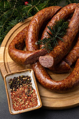 Traditional meat delicacies, sausages on a dark table
