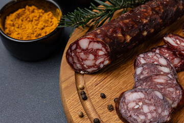 Traditional meat delicacies, sausages on a dark table
