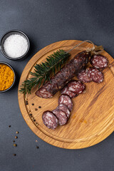 Traditional meat delicacies, sausages on a dark table
