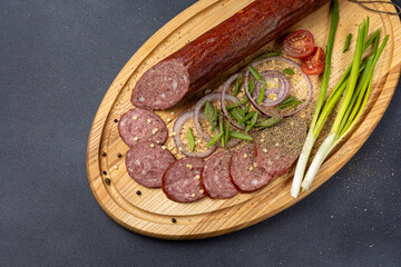 Traditional meat delicacies, sausages on a dark table
