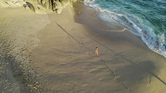 Aerial view of a person walking on the beach at Playa del Divorcio, Cabo San Lucas, Baja California, Mexico.