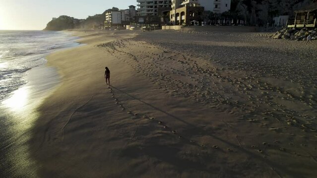 Aerial view of a person walking on the beach at Playa del Divorcio, Cabo San Lucas, Baja California, Mexico.