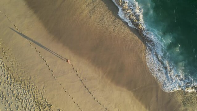 Aerial view of a person walking on the beach at Playa del Divorcio, Cabo San Lucas, Baja California, Mexico.