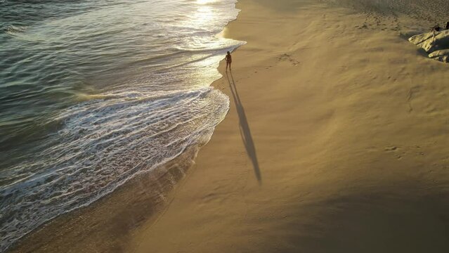 Aerial view of a person walking on the beach at Playa del Divorcio, Cabo San Lucas, Baja California, Mexico.