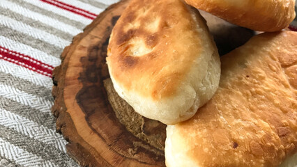 pies made of dough on a wooden board on the background of a woven towel ©  Mila Lazo
