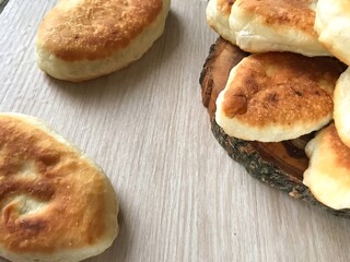 pies made of dough on a wooden board on the background of a woven towel
