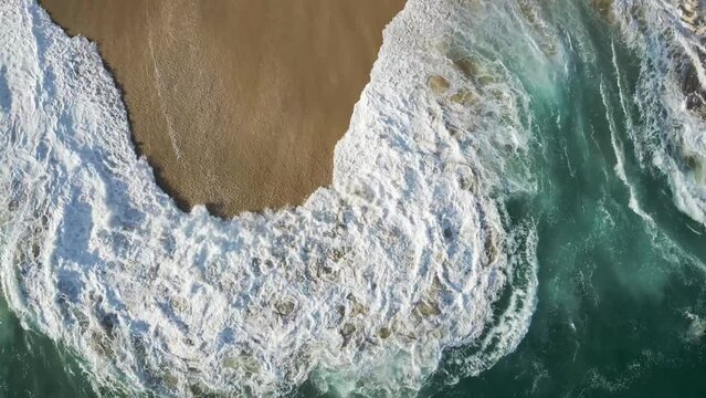 Aerial view of waves breaking on the shoreline at Playa del Divorcio, Cabo San Lucas, Baja California, Mexico.