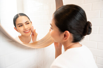 Fototapeta premium Young woman cleaning removing makeup on her face in bathroom at home , beauty wellness concept