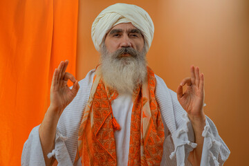 Senior man in a turban is associated with a Hindu, Jain, Buddhist.  Prayer gesture.