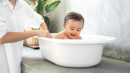 Adorable baby girl taking a bath with mother, family, child, childhood and parenthood concept