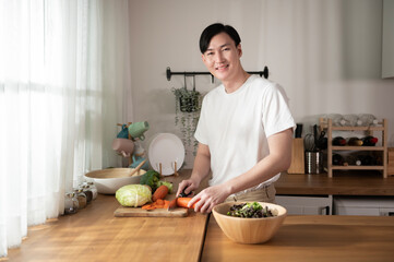 An Asian young man cooking , preparing breakfast with healthy food in kitchen at home , healthy lifestyle