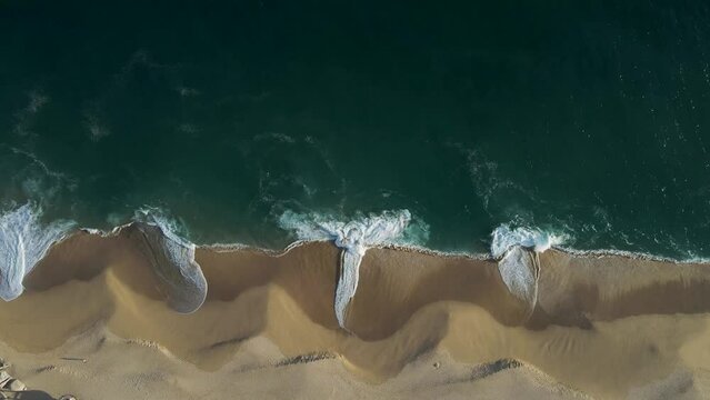 Aerial view of waves breaking on the shoreline at Playa del Divorcio, Cabo San Lucas, Baja California, Mexico.