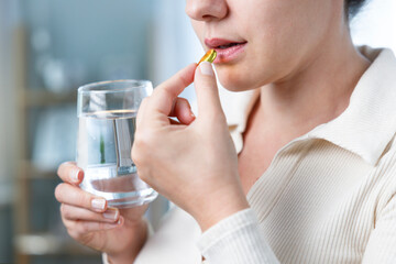 Young woman taking Omega 3 capsule