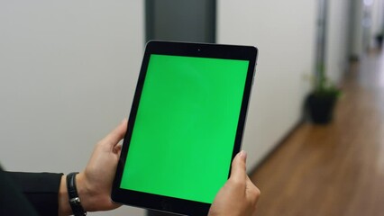 Hands holding green tablet template in office closeup. Employee video calling