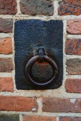 An iron horse tie ring built into the wall from a bygone era. Seen in the old city of Zutphen, Netherlands