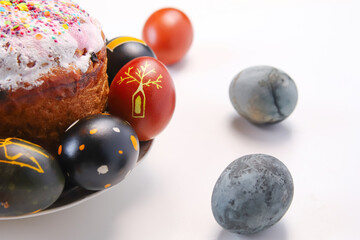 Defocus Easter black egg with tree ornament. Easter cake craffin. Close up Easter eggs pastel colored on white background. Minimal Easter celebration concept. Out of focus