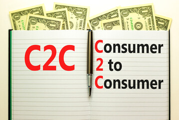C2C consumer to consumer symbol. Concept words C2C consumer to consumer on white note on a beautiful background from dollar bills. Business and C2C consumer to consumer concept. Copy space.