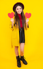 Happy teenager portrait. Young teenager child girl with heart shape. Happy Valentines Day. Love and pleasant feelings concept. Smiling girl.