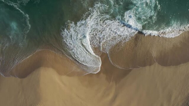 Aerial view of waves breaking on the shoreline at Playa del Divorcio, Cabo San Lucas, Baja California, Mexico.