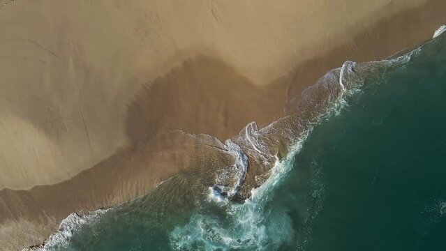Aerial view of waves breaking on the shoreline at Playa del Divorcio, Cabo San Lucas, Baja California, Mexico.