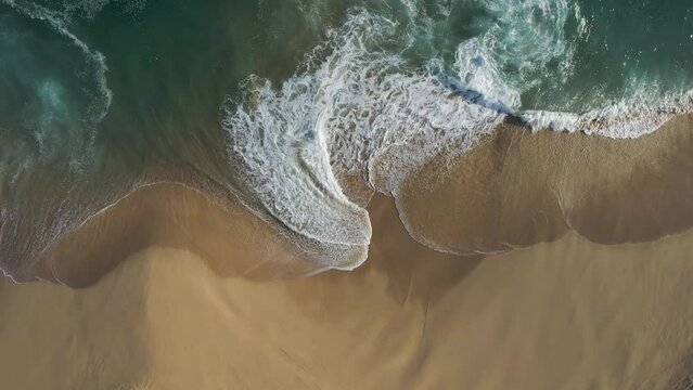 Aerial view of waves breaking on the shoreline at Playa del Divorcio, Cabo San Lucas, Baja California, Mexico.