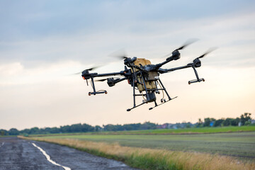 Modern smart farm with drone. Agriculture drone fly to Ready spray fertilizer on the rice fields.	