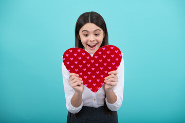 Excited face. Teenage girl hold shape heart, heart-shape sign. Child holding a red heart love holiday valentine symbol. Amazed expression, cheerful and glad.