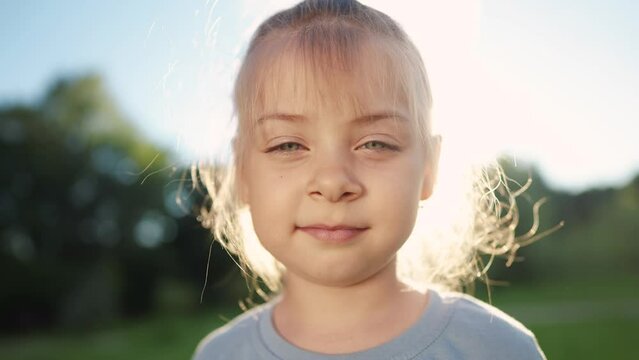 portrait of a little girl in the park. happy family kid dream concept. face child girl. close-up baby baby outdoors in the park. cute little girl looking at lifestyle the camera in nature