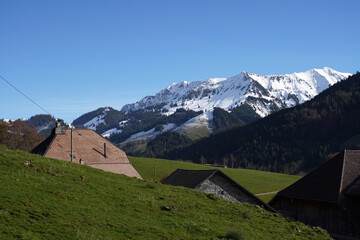 Ch&acirc;let suisse en automne, devant les sommets enneig&eacute;s