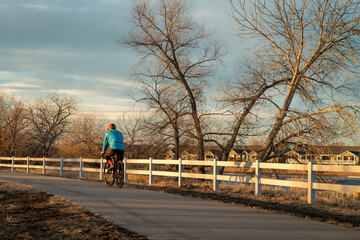 male cyclist is riding a gravel bike on one of numerous bike trails in northern Colorado in fall or winter scenery - Poudre River Trail near Windsor