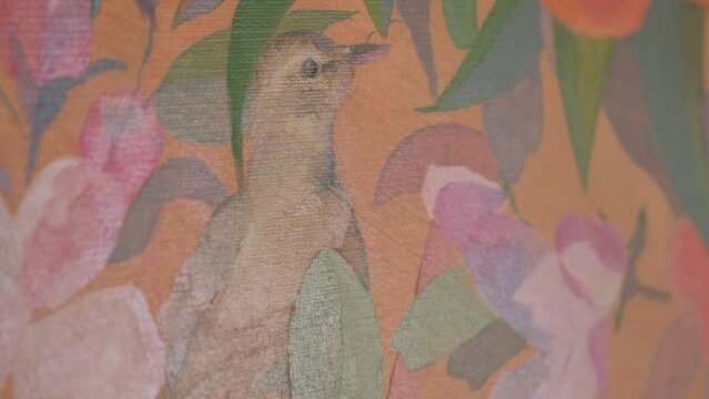 close-up of parts of a painted picture on canvas, birds, fruits, leaves, plants, face, hand, ornament