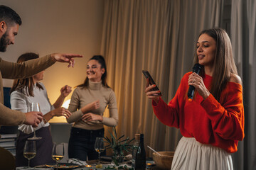 Adult woman sings a song on karaoke night at a home party