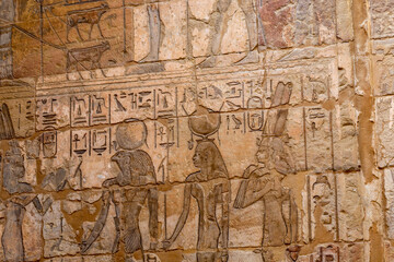 Hieroglypic painted carvings on wall at the ancient egyptian temple in Luxor. Egypt.