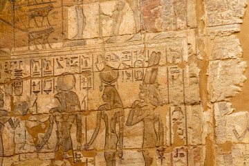 Fototapeta na wymiar Hieroglypic painted carvings on wall at the ancient egyptian temple in Luxor. Egypt.