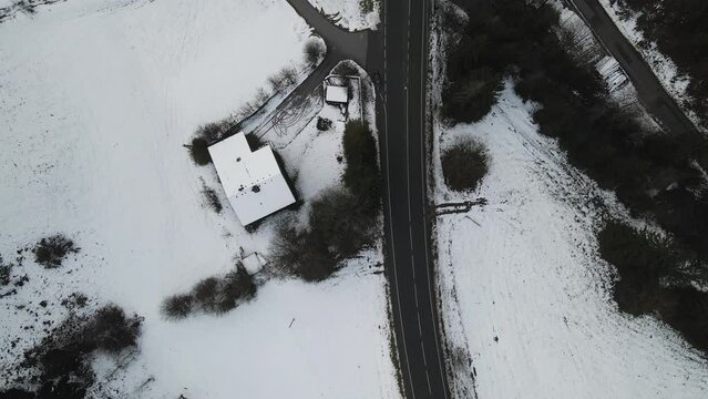 Aerial view of a road crossing the forest in winter in Eben Im Pongau, Salzburg, Austria.