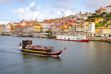 Fototapeta na wymiar Traditional boats on Rio Douro. Portugal old town cityscape and Dom Luis I bridge in Porto, Portugal.