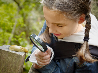 Girl Examining a Banana Slug Through a Magnifying Glass
